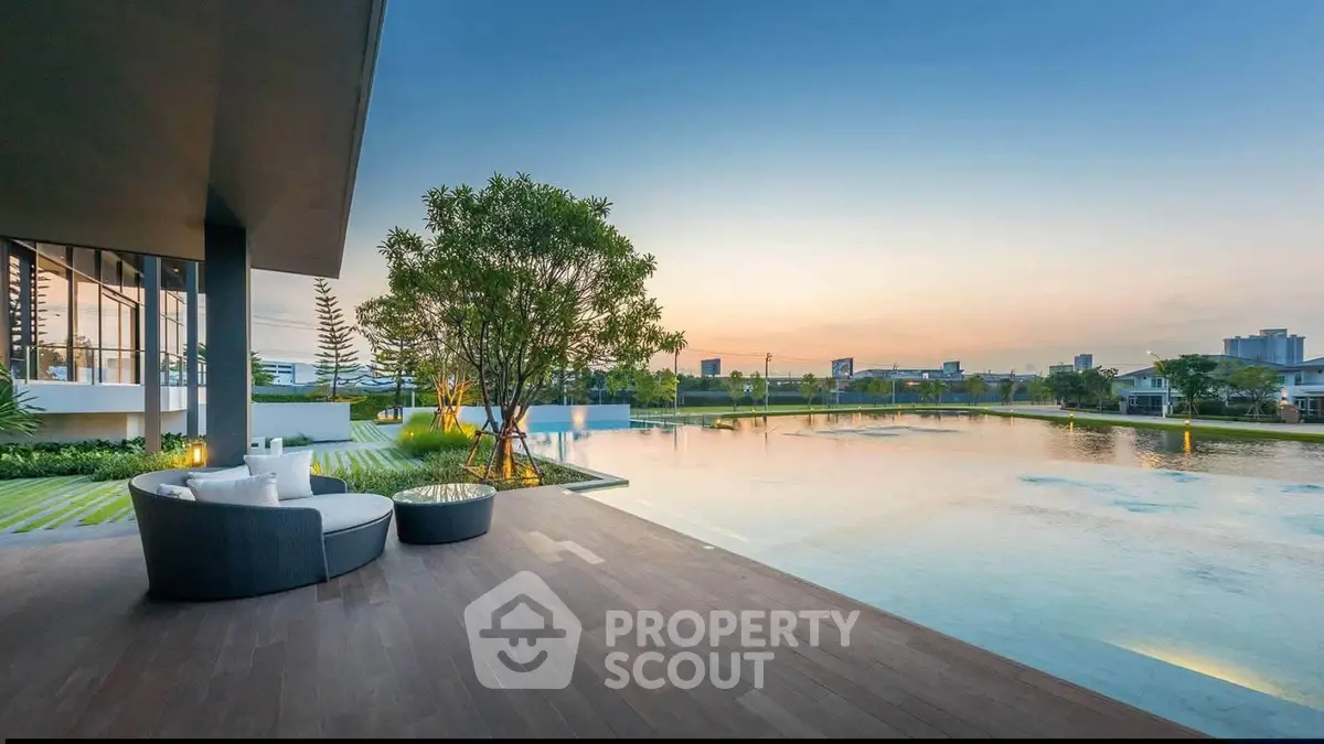 Luxurious modern poolside view with elegant outdoor seating and stunning cityscape backdrop at sunset.