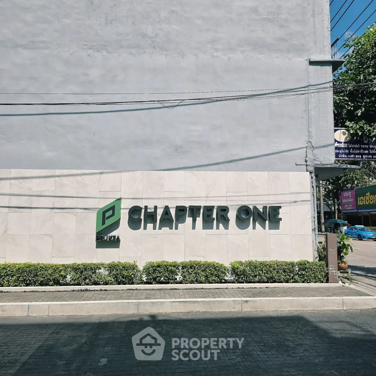 Modern building exterior with Chapter One signage and lush greenery.