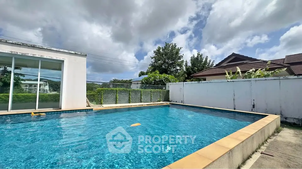 Stunning private pool with clear blue water and lush surroundings, perfect for relaxation and leisure.