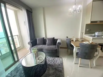 Chic modern living room with balcony view, plush grey sofa, elegant dining set, and stylish decor.