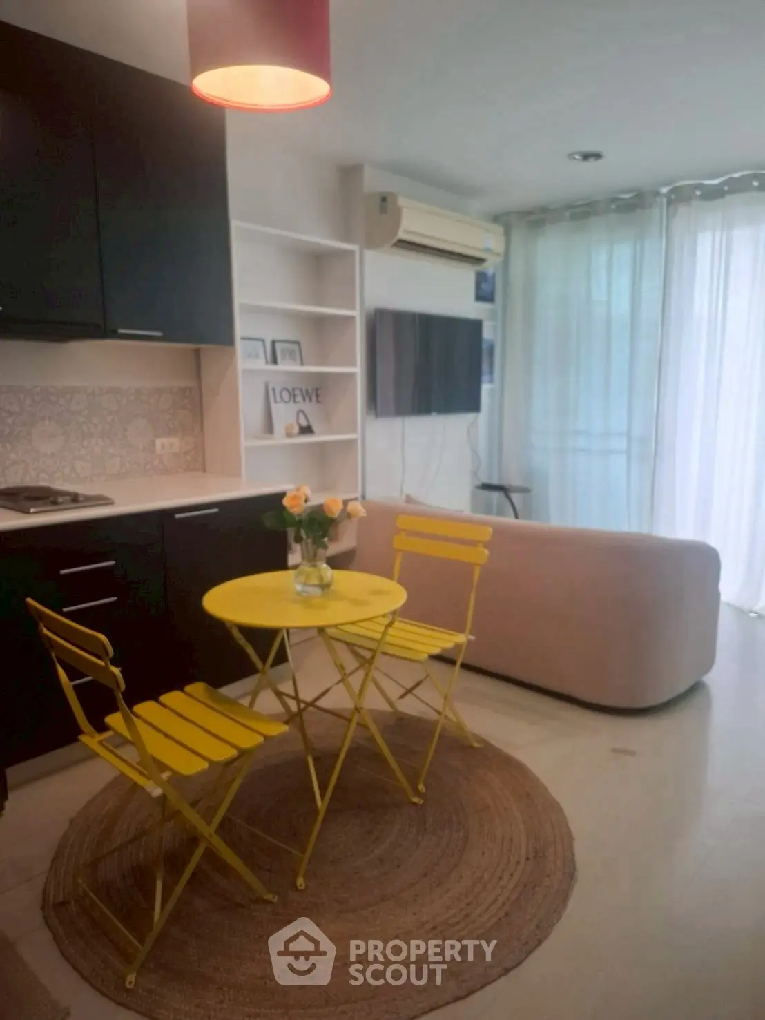 Chic modern living room with vibrant yellow chairs and sleek kitchen area.