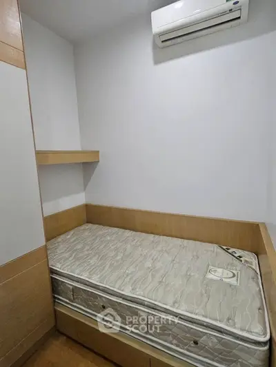 Cozy small bedroom with built-in storage and air conditioning