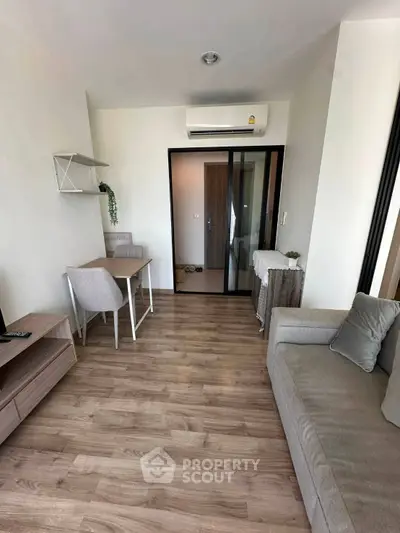 Modern living room with wooden flooring, cozy sofa, and air conditioning in a stylish apartment.