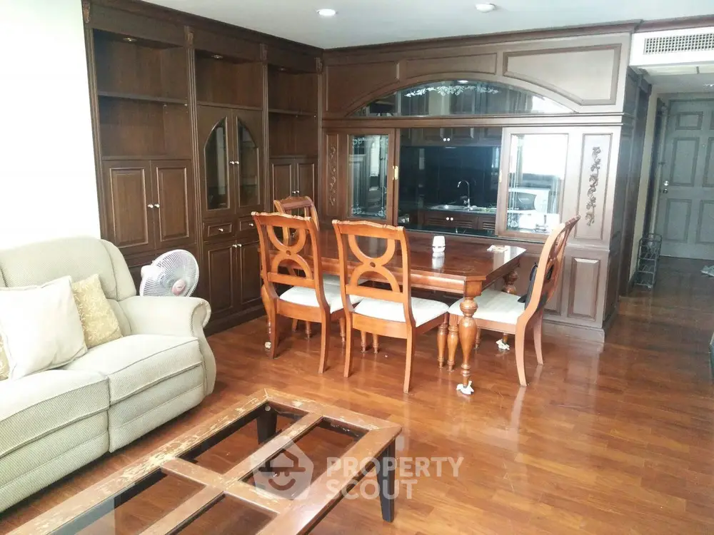Elegant living room with wooden furniture and built-in cabinets, perfect for cozy gatherings.