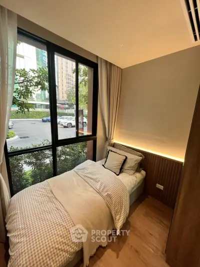 Cozy bedroom with large window and modern decor in urban setting
