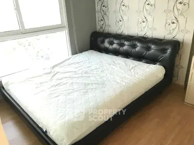 Cozy bedroom with stylish leather bed and large window for natural light