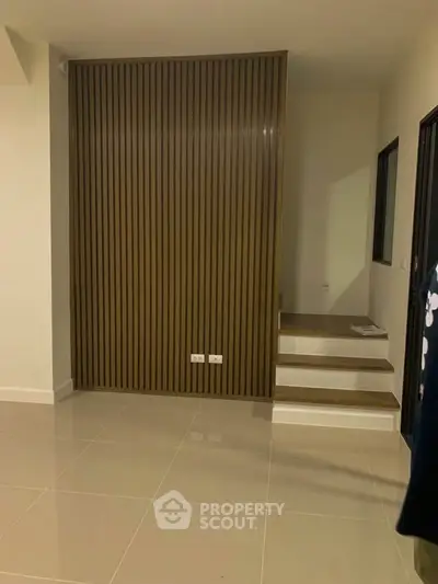 Modern interior with sleek wooden paneling and tiled flooring, showcasing minimalist design.