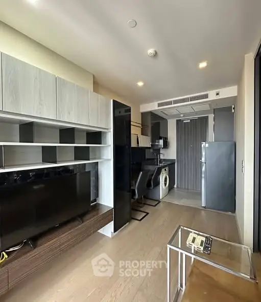 Modern living room with sleek furniture and open kitchen layout in a stylish apartment.