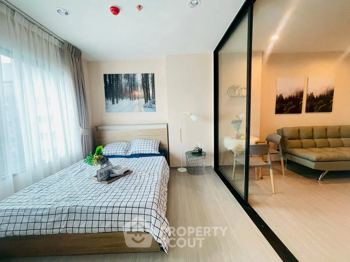 Modern bedroom with stylish decor and adjacent living area in a contemporary apartment.