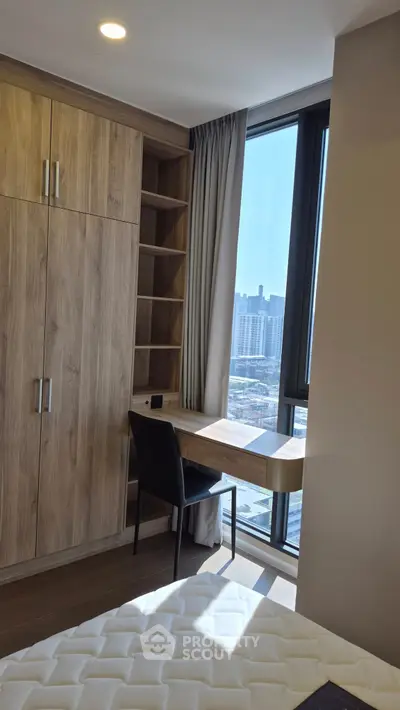 Modern bedroom with built-in wooden wardrobe and study desk, offering a stunning city view.