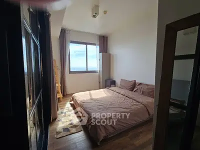 Spacious bedroom with large window offering stunning views, featuring cozy bedding and modern decor.