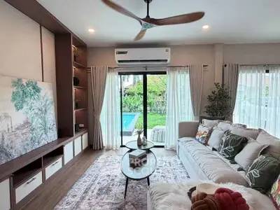 Charming living room with pool view, cozy sofa, and elegant decor in a modern home.