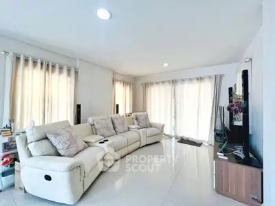 Spacious living room with modern white sofas and large windows for natural light.