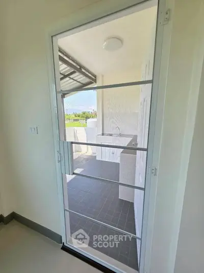 Modern balcony with sleek door and outdoor sink, perfect for relaxation and utility.