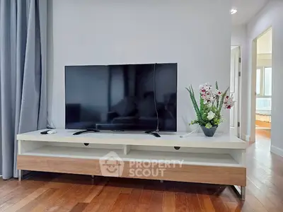 Modern living room with sleek TV setup and elegant wooden flooring.