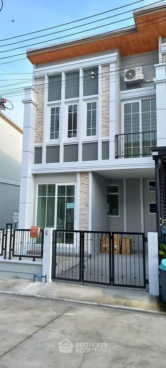 Modern two-story townhouse with stylish facade and gated entrance