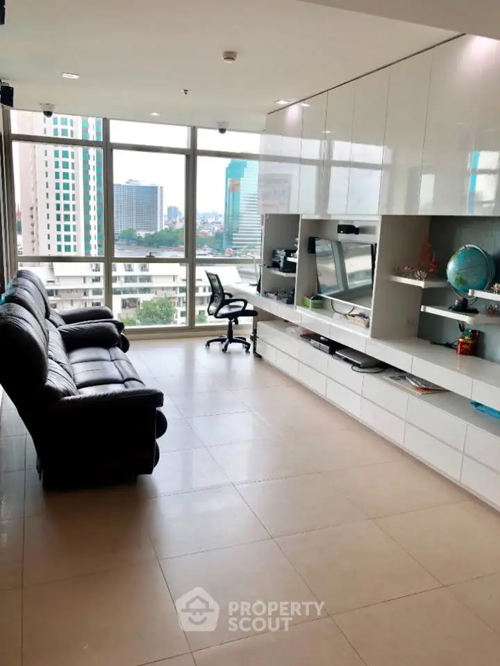 Spacious modern living room with city view, sleek furniture, and ample natural light.