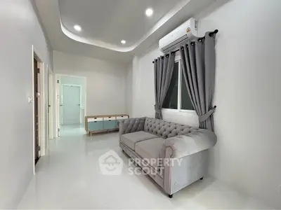 Modern living room with elegant gray sofa and stylish curtains in a bright, minimalist space.