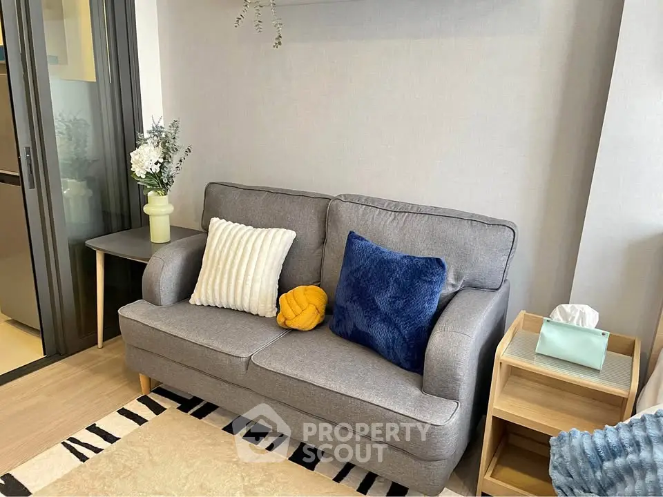 Cozy living room with stylish gray sofa and colorful cushions in modern apartment.