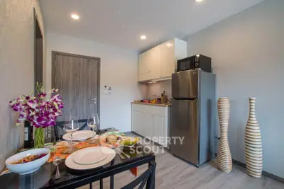 Modern kitchen with dining area, stainless steel fridge, and elegant decor