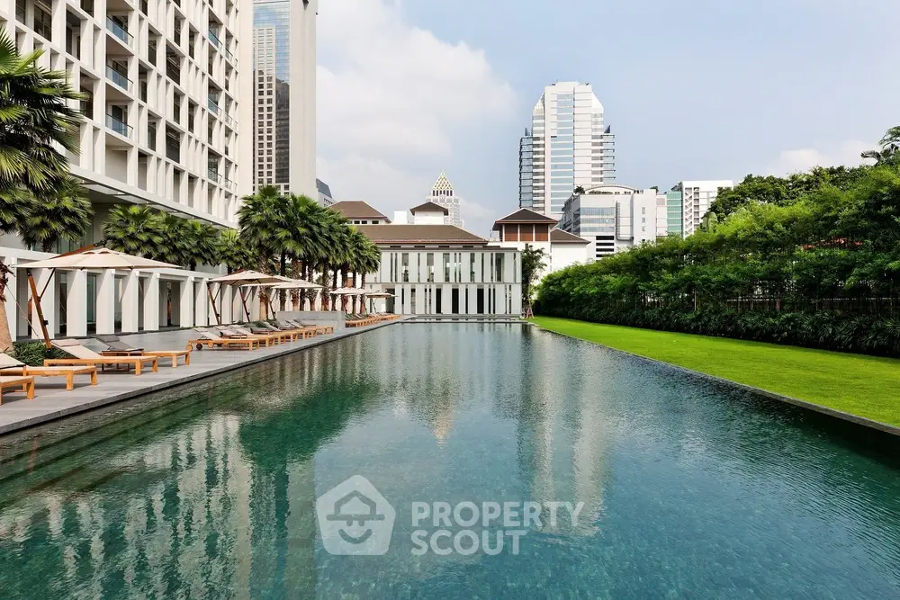 Luxurious urban poolside with city skyline views and lush greenery.