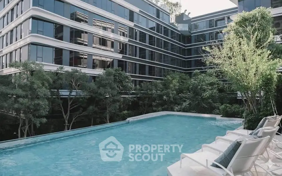 Luxurious modern apartment complex with stunning pool and lush greenery