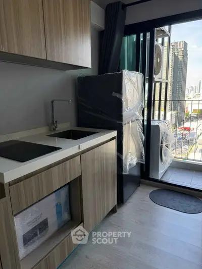 Modern kitchen with sleek cabinetry and balcony view in urban apartment