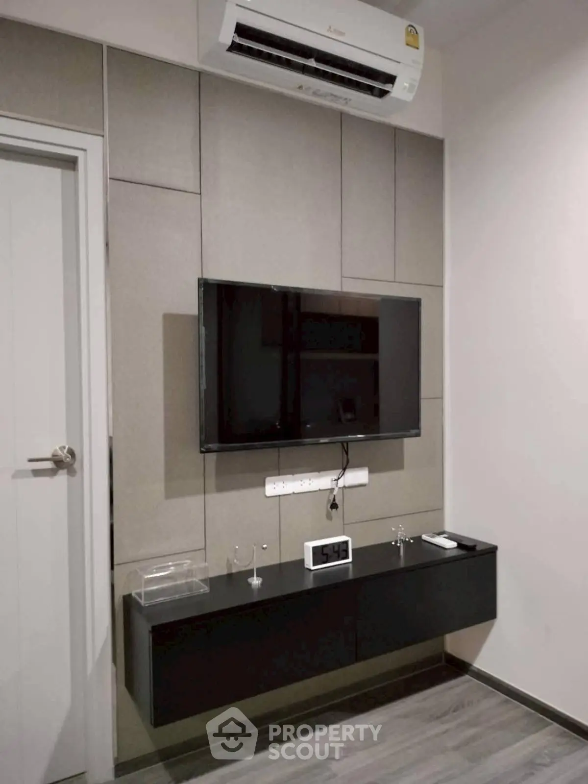 Modern living room with wall-mounted TV and sleek air conditioning unit.