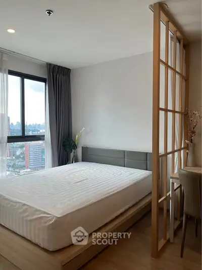 Modern bedroom with city view and stylish partition in high-rise apartment.