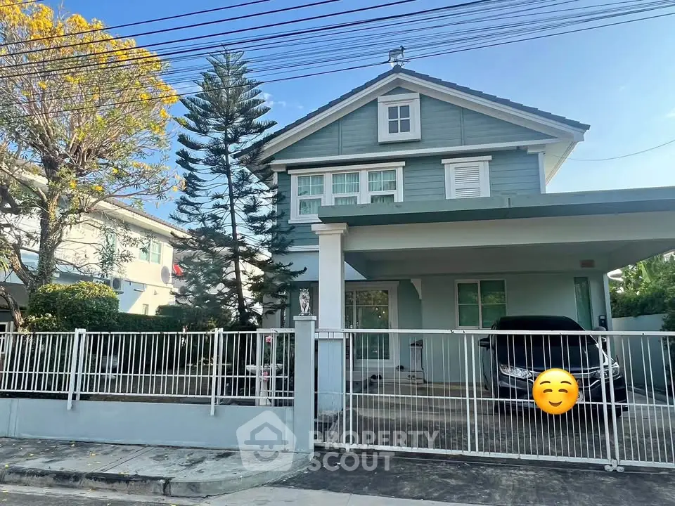 Charming two-story house with a spacious driveway and lush greenery, perfect for family living.