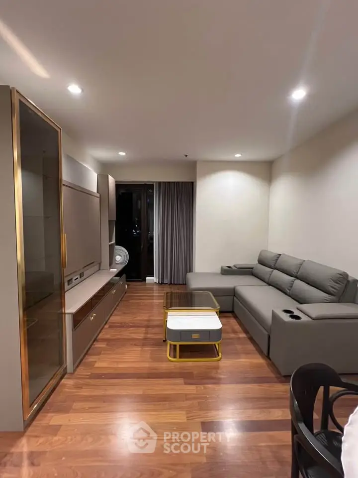 Modern living room with sleek furniture and wooden flooring, perfect for cozy family gatherings.
