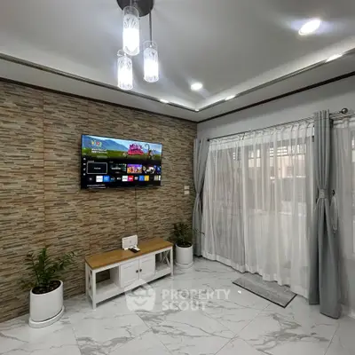 Modern living room with stylish decor, wall-mounted TV, and elegant lighting.