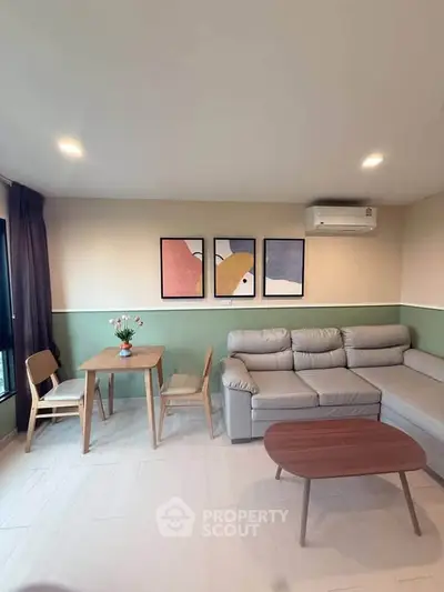 Modern living room with stylish furniture and wall art, featuring a cozy sofa and dining area.