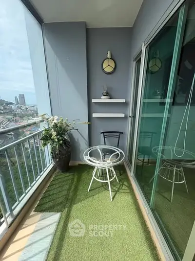 Charming balcony with artificial grass and city view, perfect for relaxation.