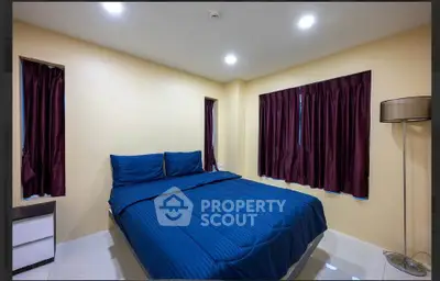 Cozy bedroom with blue bedding and elegant curtains in modern apartment.