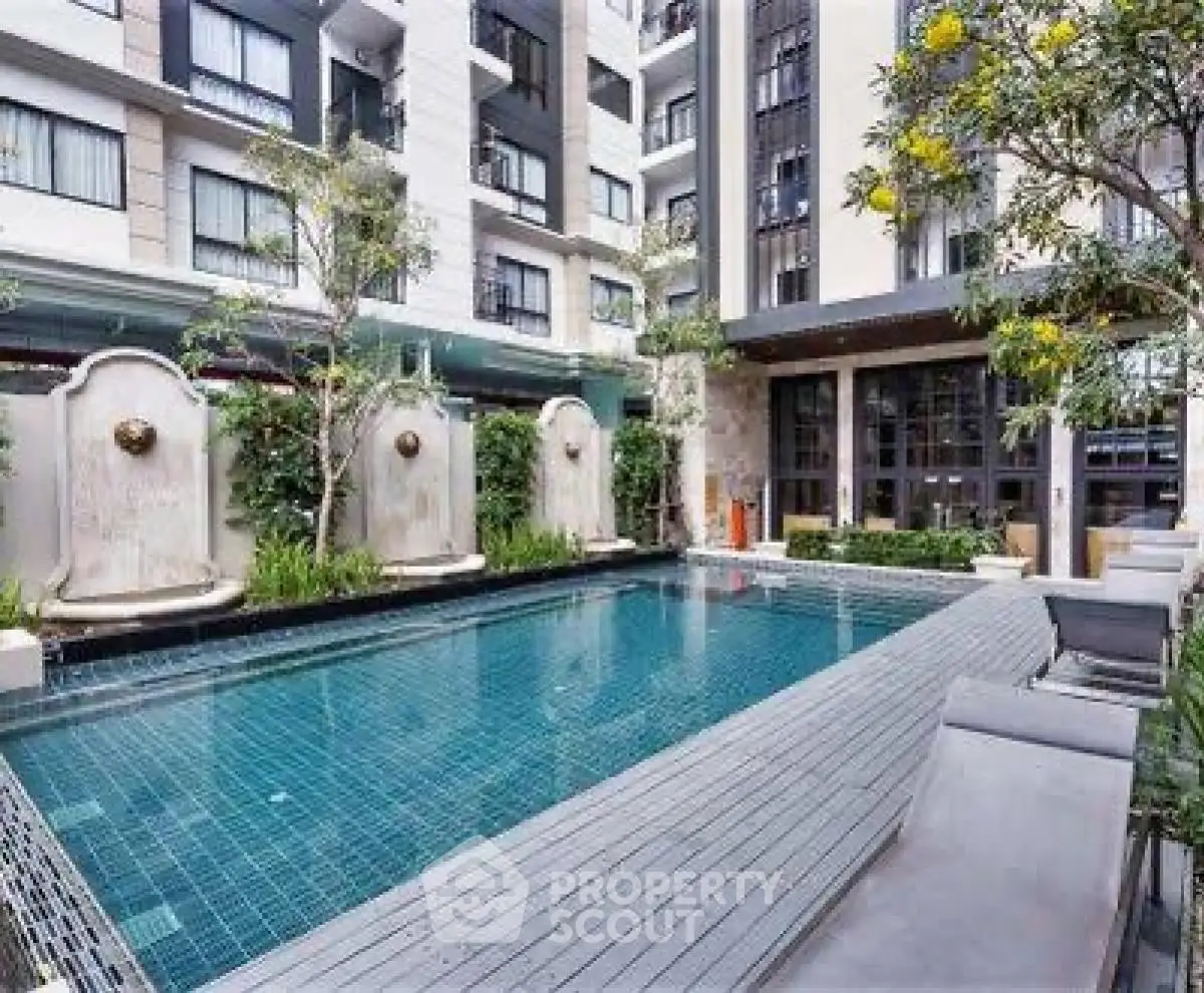 Luxurious apartment complex with modern pool and lush greenery