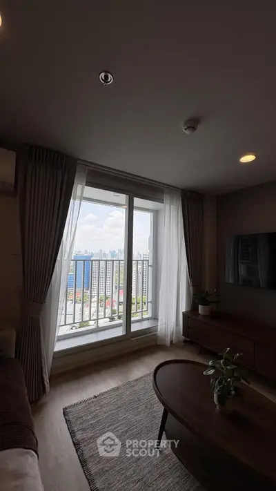 Modern living room with balcony offering stunning city skyline view, perfect for urban living.