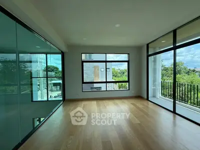 Spacious room with large windows and balcony offering scenic views.