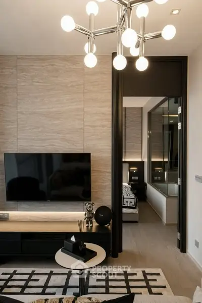 Modern living room with stylish decor and view into a chic bedroom