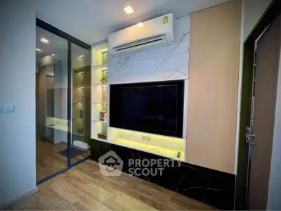 Modern living room with sleek TV setup and stylish shelving in a contemporary apartment.
