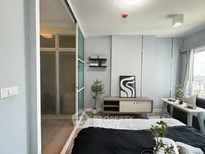 Modern bedroom with stylish decor and large window offering city views