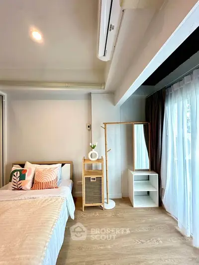 Cozy bedroom with modern decor and natural light, featuring a stylish bed and elegant wooden furniture.