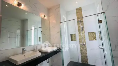 Luxurious bathroom with dual sinks and modern glass shower enclosure