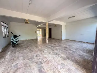 Spacious open area with tiled flooring and natural light, ideal for versatile use.