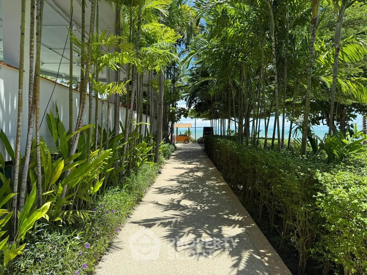 Lush garden pathway leading to a serene beachfront view, perfect for relaxation and tranquility.