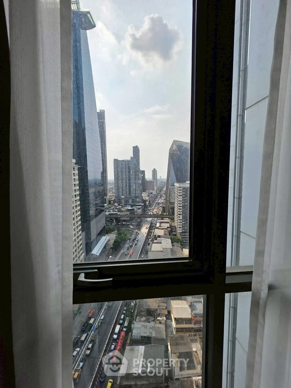 Stunning cityscape view from a high-rise window, showcasing urban skyline and bustling streets below.