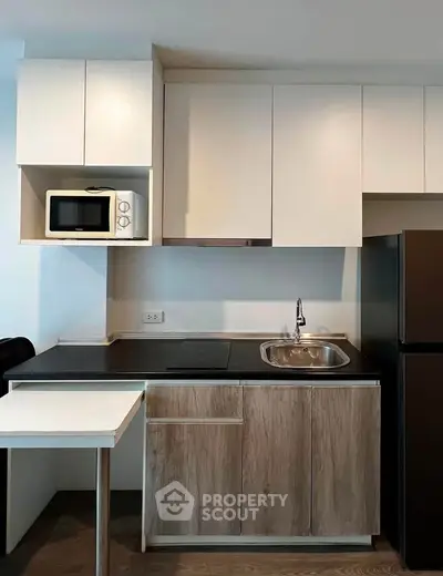 Modern compact kitchen with sleek cabinetry and built-in appliances, perfect for urban living.