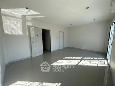 Spacious sunlit room with glossy tiled floors and modern recessed lighting.