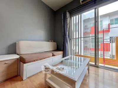 Modern living room with cozy sofa and glass coffee table, featuring a balcony view.