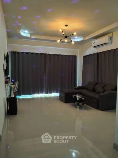Spacious living room with modern lighting and large sectional sofa, perfect for relaxation.